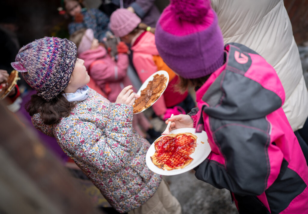 Kaksi tyttöä syö vohveleita Lomalauantai -tapahtumassa